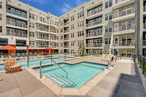 A large swimming pool in front of apartment buildings.