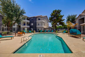 our apartments have a large swimming pool with chairs and umbrellas