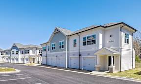 A row of houses with garages and driveways.