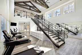 A gym with treadmills and a staircase.