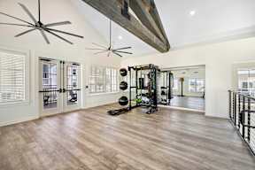 A spacious room with a wooden floor and a ceiling fan.