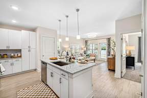 A kitchen with a sink, cabinets, and a dining table.