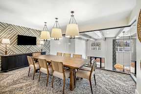 A modern dining room with a wooden table and chairs.