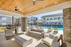 A modern outdoor living space with a pool and lounge chairs.