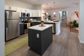 an open floor plan with a kitchen island and stainless steel appliances