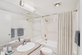 a bathroom with a shower and a sink and a toilet