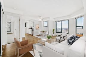 the living room of an apartment with a white couch and a table and chairs