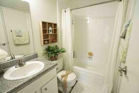 A bathroom with a white sink and a white toilet.