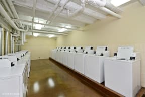 a room filled with lots of white washing machines