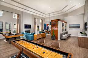 A shiny billiard table is in the middle of a well-furnished room.
