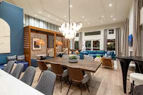 A modern dining room with a large table and chairs.