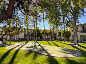 A park with a green lawn and trees.