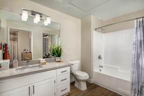 A white bathroom with a toilet, sink, and bathtub.