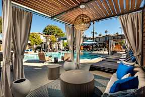 A poolside lounge area with blue cushions and a wooden ceiling.