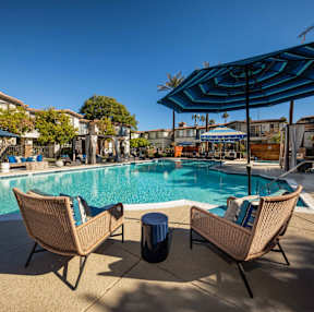 Two chairs are placed on a patio by a pool.