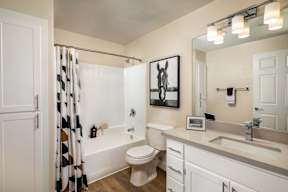A bathroom with a toilet, sink, and shower.