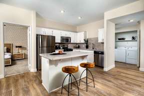 A kitchen with white cabinets and a wooden floor.