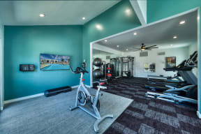 a home gym with a blue wall and a bike in the middle of the room