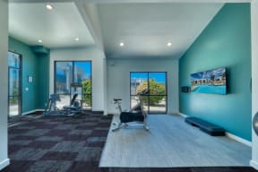 a workout room with blue walls and a view of the pool