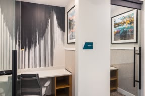 a conference room with a desk and a wall with paintings on it