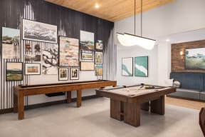 a games room with a pool table and pictures on the wall