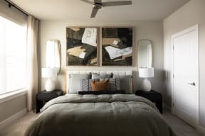 a bedroom with a bed and two paintings on the wall