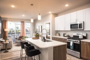 an open kitchen and living room with a large white counter top