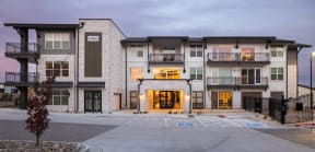 an image of an apartment building with an empty parking lot