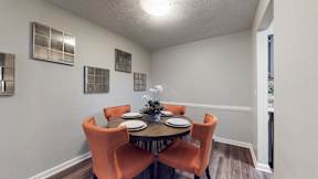 A dining room with a table set for four.