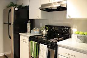 A black stove top oven with a green towel