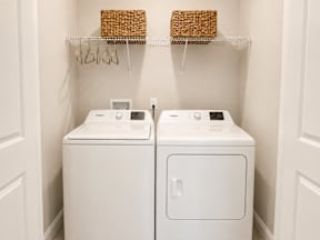 Two white washing machines in a laundry room.