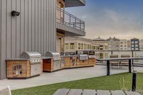 A modern outdoor kitchen area with grills and a dining table.