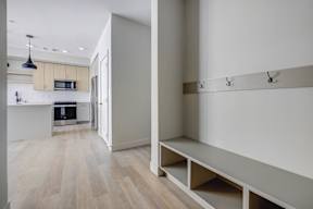 A kitchen with a white counter top and a white wall.