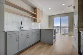 A modern kitchen with white cabinets and a wooden countertop.