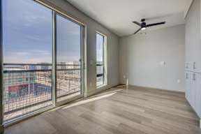 A room with a ceiling fan and sliding glass doors.