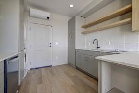 A kitchen with a white door and a white sink.