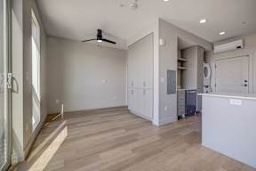 A kitchen area with a refrigerator, cabinets, and a countertop.