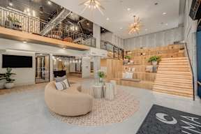 A modern interior with a staircase, a sofa, and a TV.