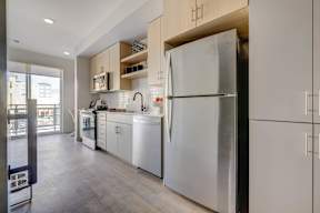 A modern kitchen with a refrigerator, oven, and sink.