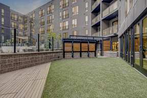 A modern building with a wooden deck and a black awning.