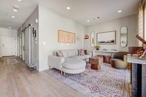 A living room with a white couch and a rug.