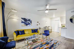 a living room with a yellow couch and blue chairs