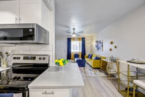a kitchen and living room with a yellow couch and blue chairs