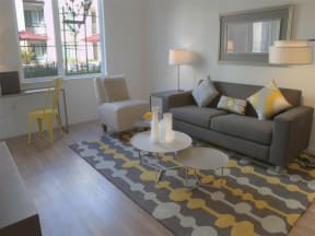 Dog Friendly Apartments in Mountain View CA - mResidences Mountain View - Liciing Room with Couch, Chair, Carpet, Window, Mirror, Coffeetable, Lamps, Monitor, and Desk