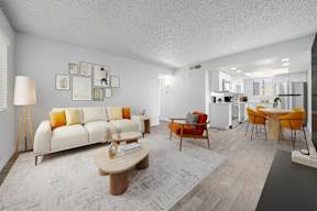 Living room with white couch and orange accents at Newport Avondale apartments for rent.
