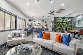 A living room with a white couch and a glass coffee table.