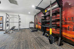 A gym with a red wall and a sign that says "Train & Zone".