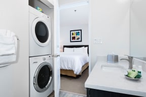 Apartments Sunnyvale, CA - mResidences Silicon Valley - Interior Shot Of The Bathroom Featuring In-Unit Washer & Dryer, Undermount Sink, And Large Mirro