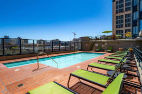 a pool on the top of a building with a city in the background