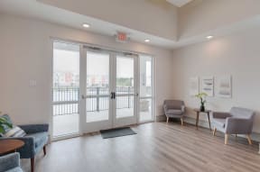 a living room with glass doors and chairs and a table